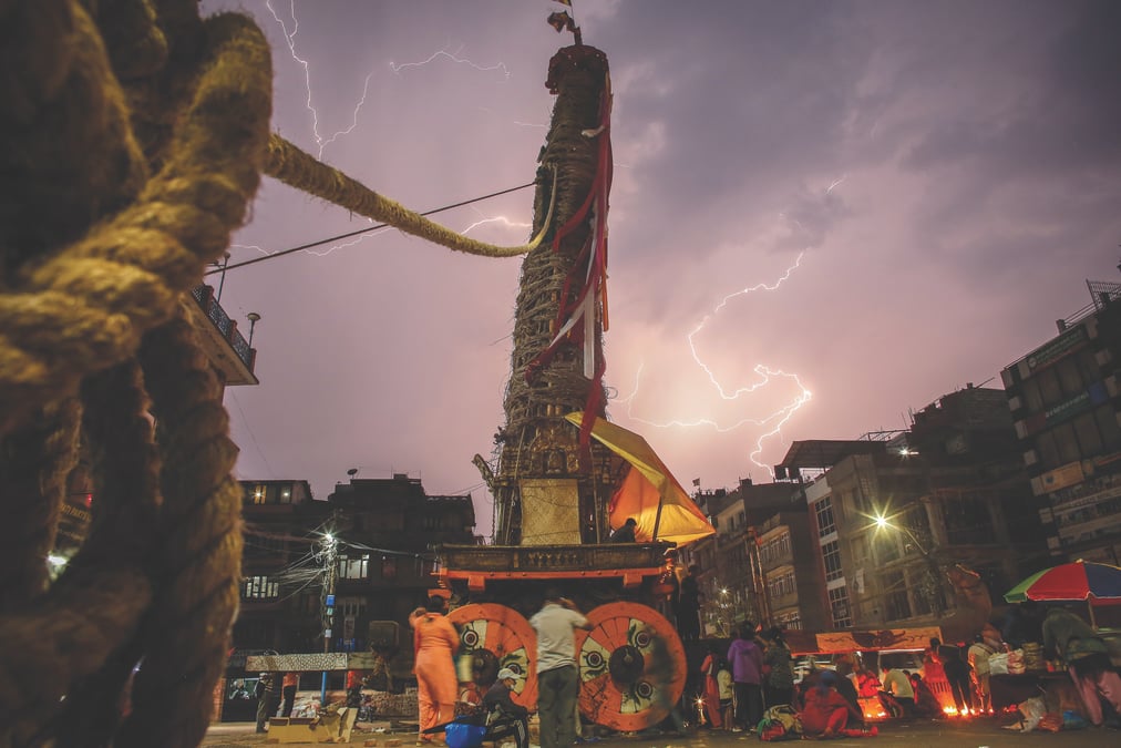 ALL LIT UP: The Machindranath chariot undergoing final touches during a thunderstorm on Monday. The chariot of the rain god needed structural repairs after leaning on homes in Na Tole during the first day of its month-long journey. Photo: DINESH SHRESTHA