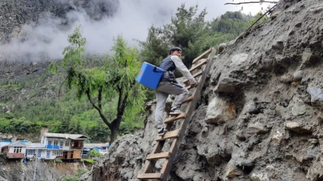 A healthcare worker delivers vaccines in Manang through treacherous roads after climate-induced flash floods in 2021. Photo: BADRI ACHARYA