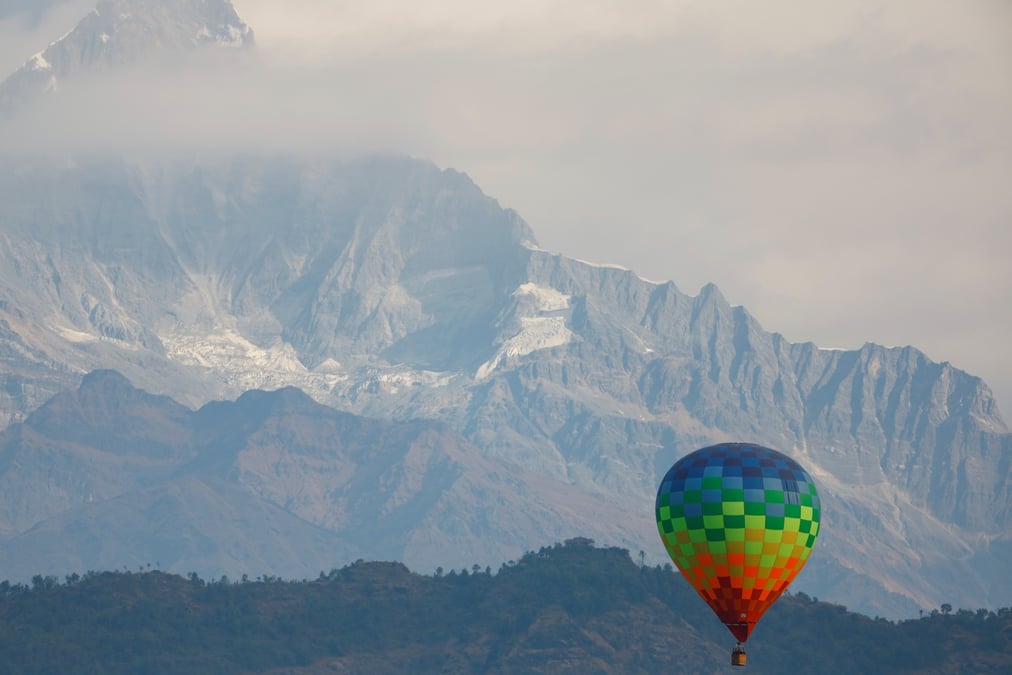 HOT AND COLD: A balloon takes off from Pame near Pokhara on Tuesday below overcast skies, and against a backdrop of a snowless Mt Machapuchre (6,693m). Photo: SKANDA GAUTAM