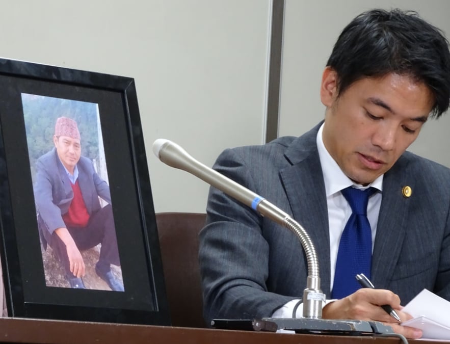 Japanese human rights lawyer Yoshihito Kawakami next to the portrait of Nepali migrant worker who died in police custody in 2017. The Tokyo High Court announced a JPY39 million compensation to Singh’s family in Nepal. SAKURA MURAKAMI / THE JAPAN TIMES