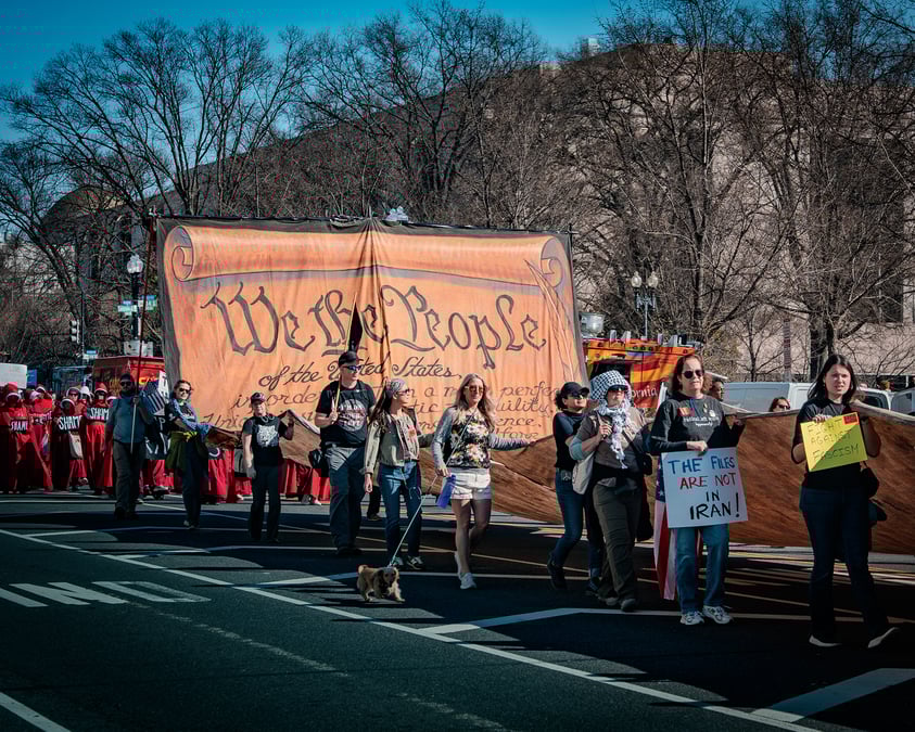 "Free Iran Demonstration" opposing the US–Israeli strikes in Washington, D.C., with the demonstrators carrying a large replica of the preamble to the United States Constitution on 28 February 2026. Photo: TED EYTAN / WIKIMEDIA COMMONS