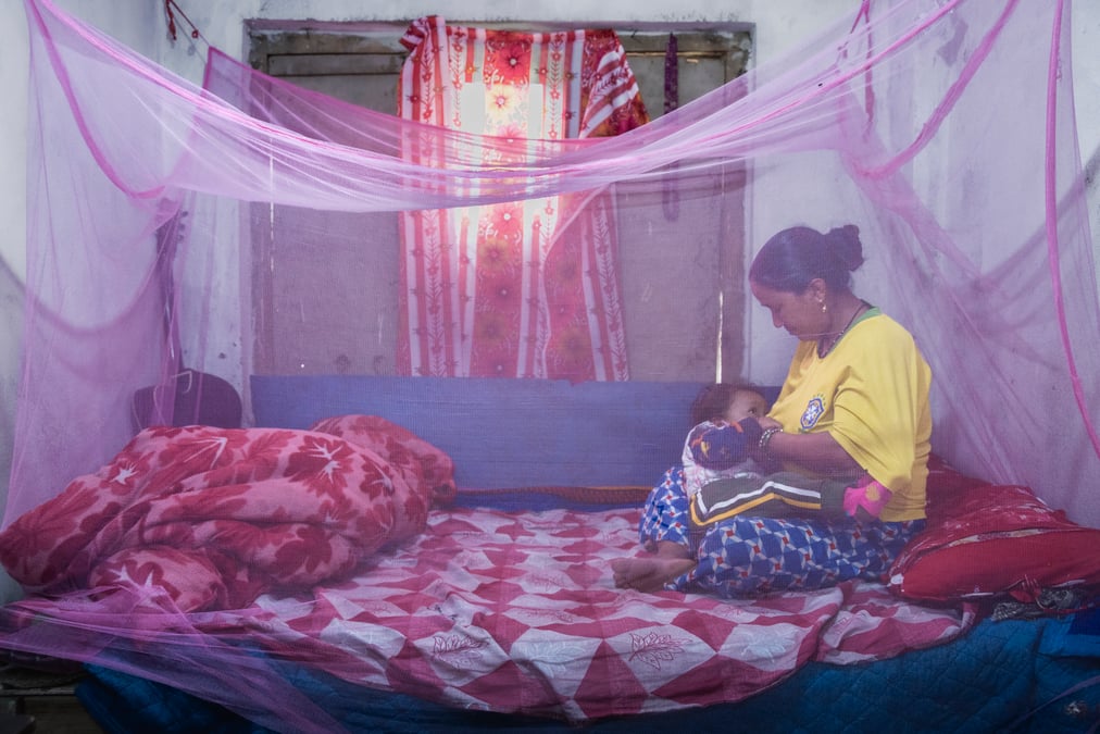 Devi Kanya Kathayat, 33, breastfeeds her son Nehan Budha, 2, under a mosquito net in their home in Chandannath, Jumla, 2,438m. He family lives at 2,438m but now need mosquito nets to prevent infection.